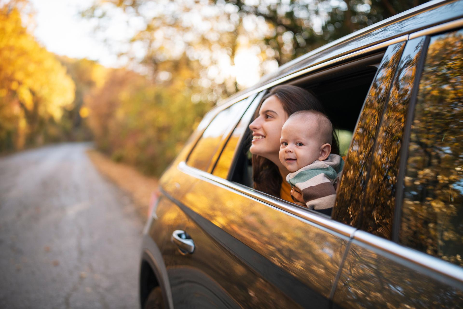 Mother and baby on a autumn road trip.
